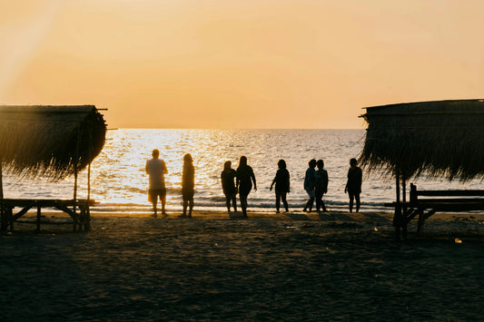 Plage de la côte landaise au coucher du soleil, ambiance minimaliste avec un tote bag éco-responsable et un t-shirt blanc en coton bio