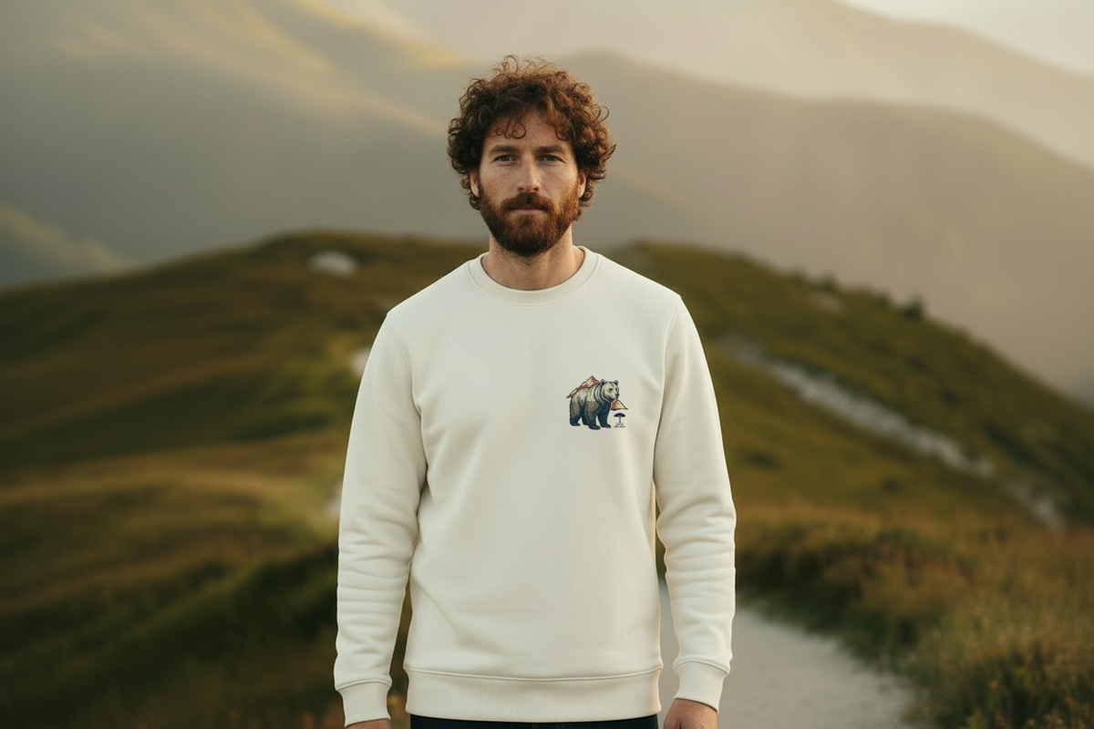 homme sur les montagnes du Béarn avec un sweat couleur ivoire orné d'un imprimé poche d'un ours des Pyrénées