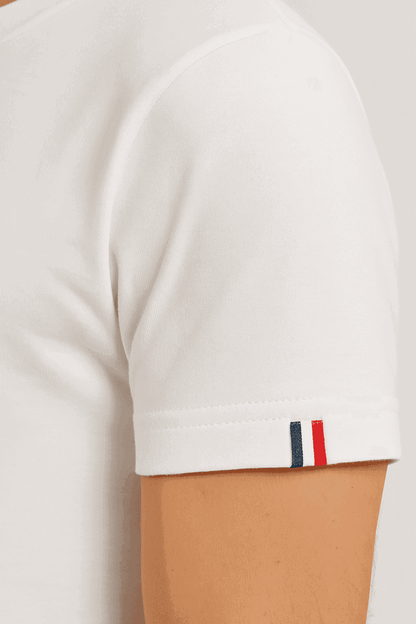 Gros plan sur la manche du sweat blanc L’Épicurien de la marque Au Fil des Pins, mettant en valeur l’étiquette bleu blanc rouge symbole du savoir-faire français et de la confection made in France.