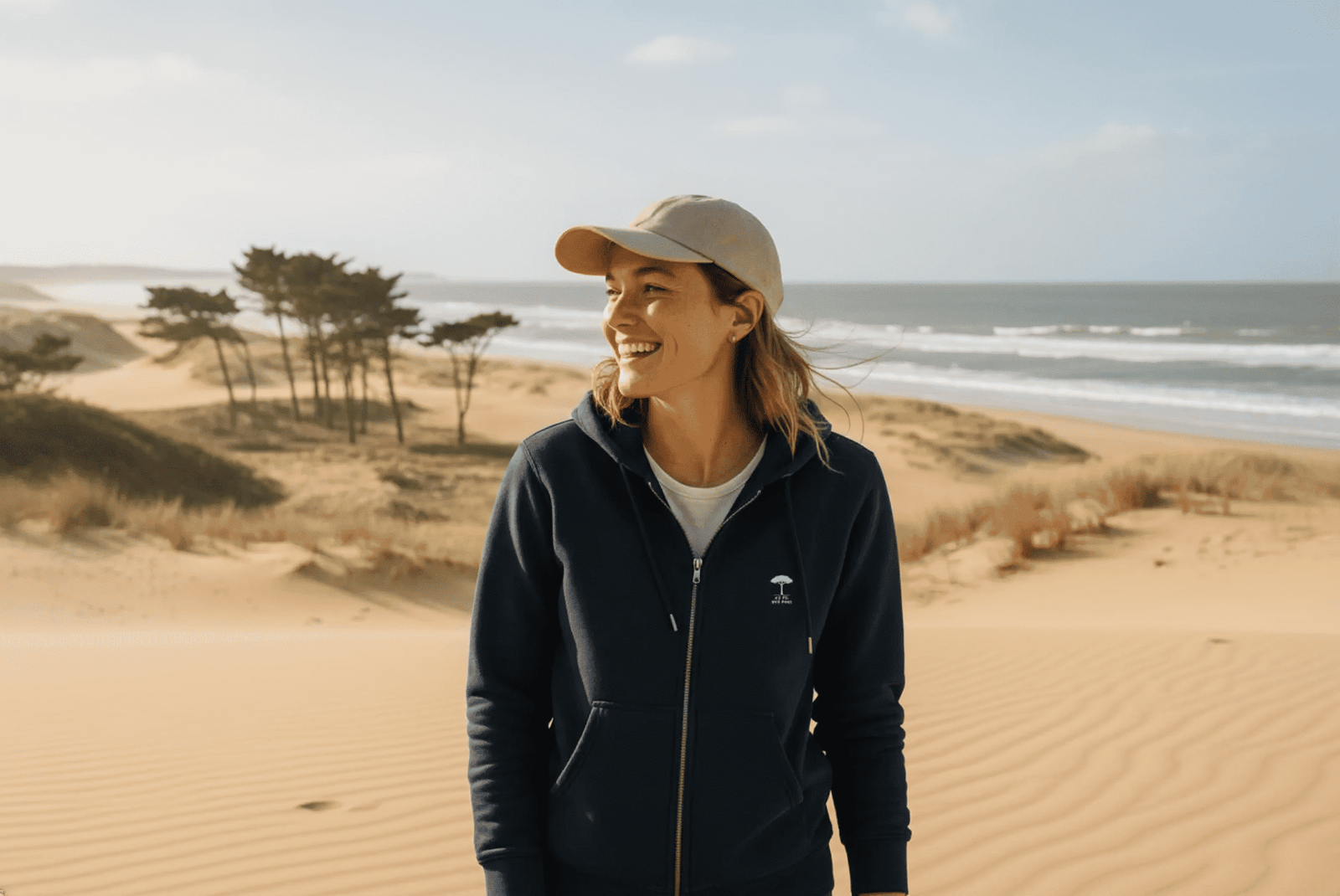 Femme portant un sweat à capuche mmarine Au Fil des Pins sur la plage des Landes
