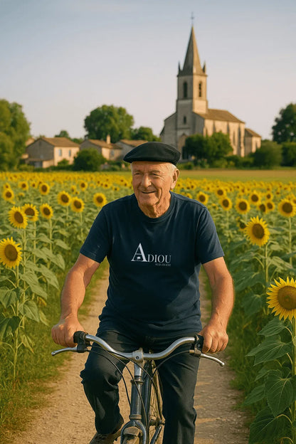 Tee‑shirt homme éco‑responsable "Adiou" porté en extérieur, devant un paysage du Sud‑Ouest — style authentique et responsable.

