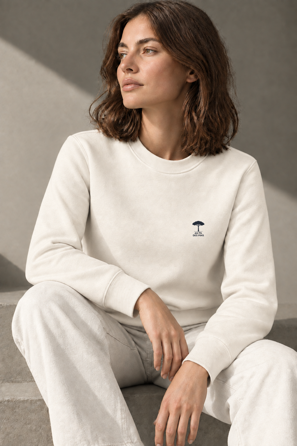 femme assise protant un sweat au fil des pins couleur ivoire