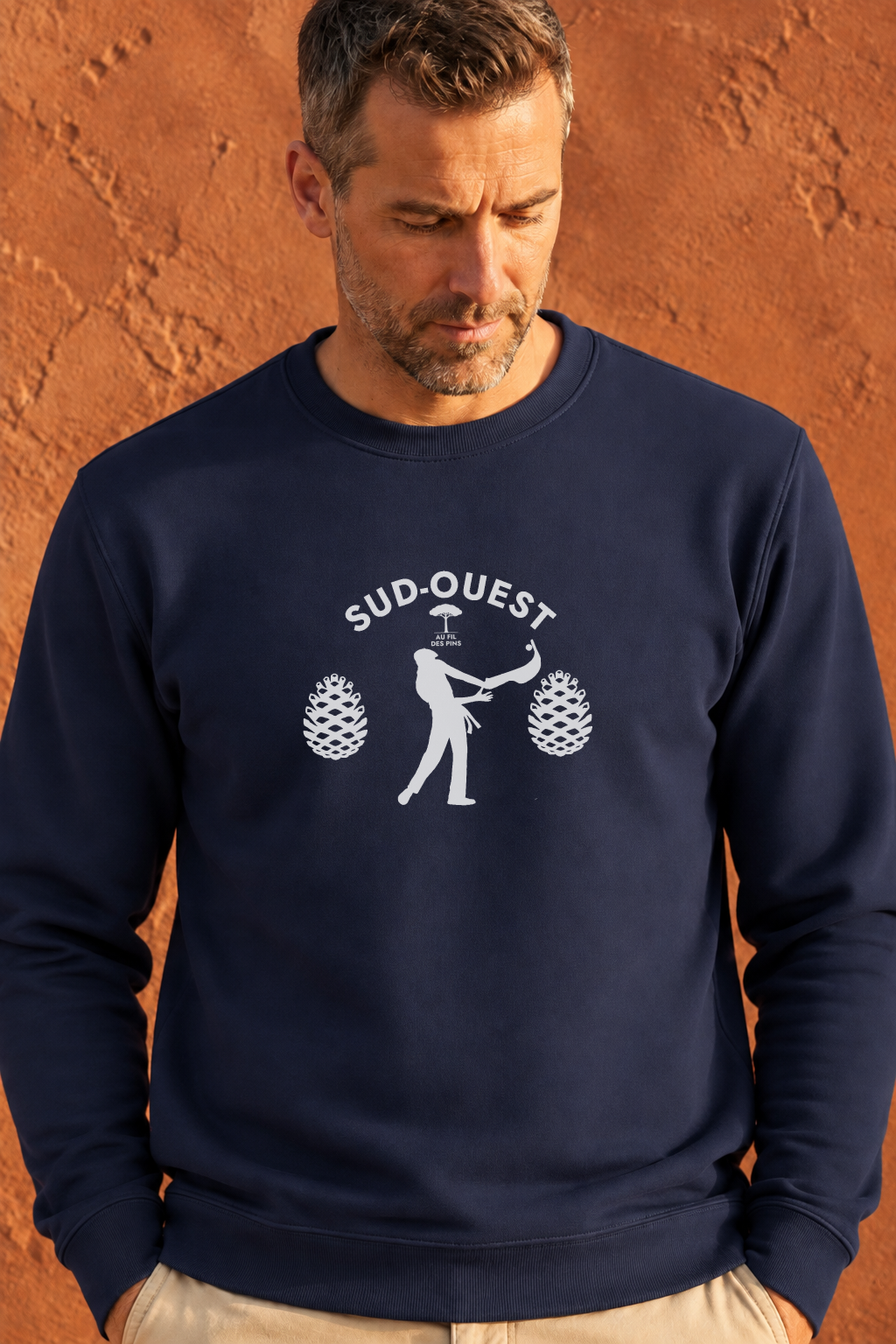 homme devant mur terracota avec sweat marine design pelote basque