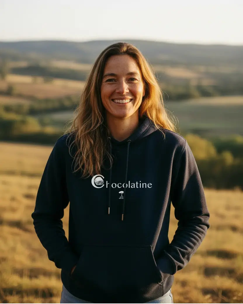 Femme en sweat à capuche Chocolatine marine coton bio devant les collines du Sud-Ouest – Au Fil des Pins
