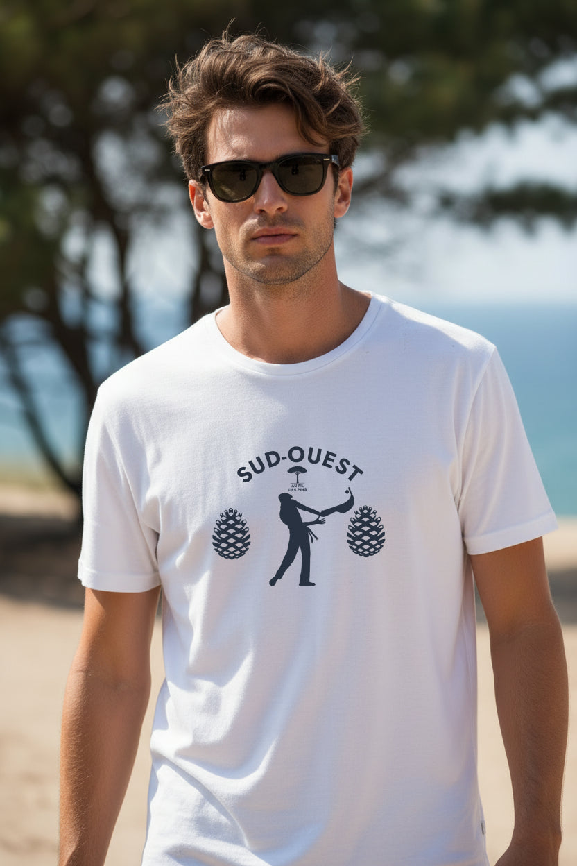Homme en t-shirt blanc Pelote Basque Sud-Ouest coton bio GOTS devant un pin parasol face à l'océan – Au Fil des Pins
