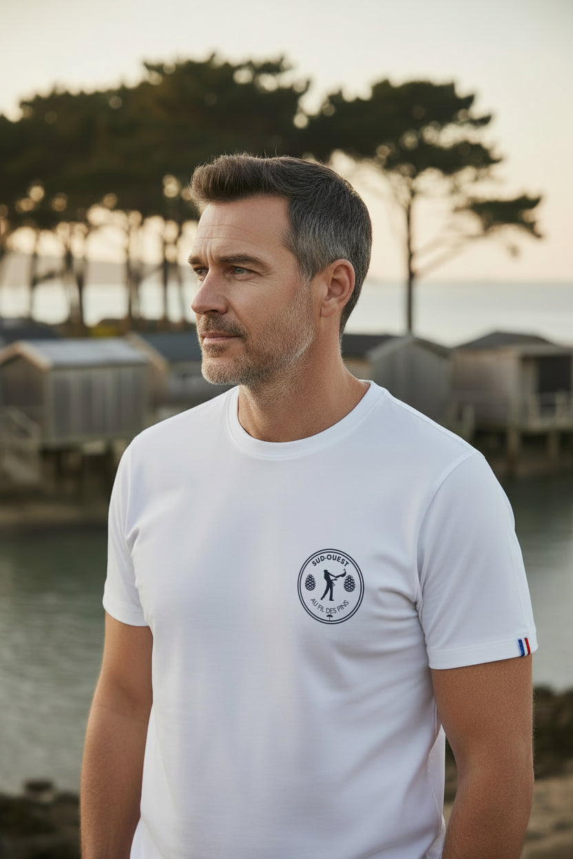 Homme en t-shirt blanc Pelote Basque Made in France devant les cabanes tchanquées d'Arcachon – Au Fil des Pins
